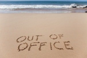 out of office written on beach