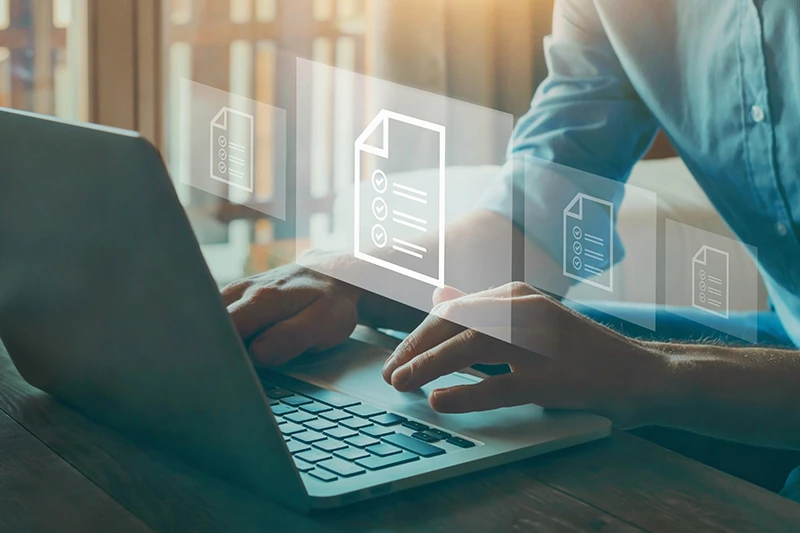 Person using a laptop with overlaid digital document and checklist icons, representing document management and review.