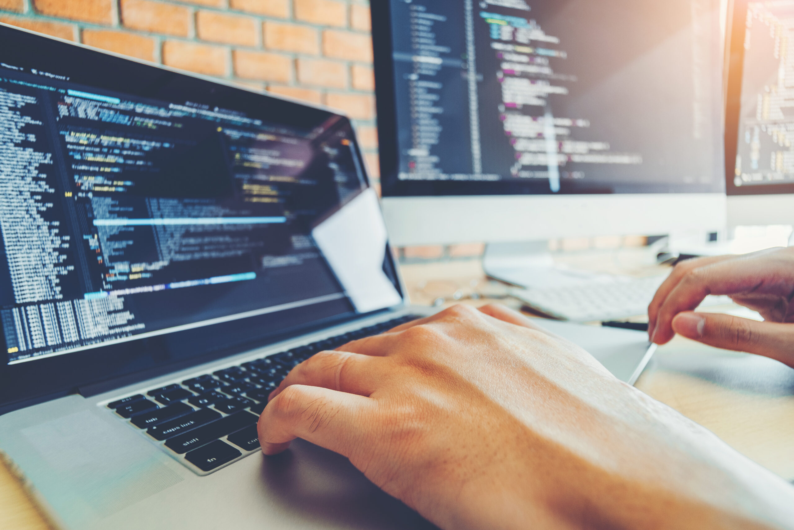 Software expert typing source code on a laptop computer