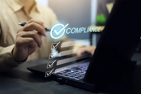 Compliance concept with businessman tick check mark with pen on laptop screen to complied and submission regulation to the market destination.