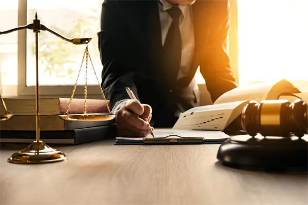 Male lawyer working with contract papers and wooden gavel on table in courtroom