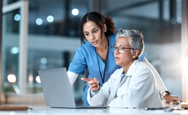 Doctor and nurse sitting at a computer planning