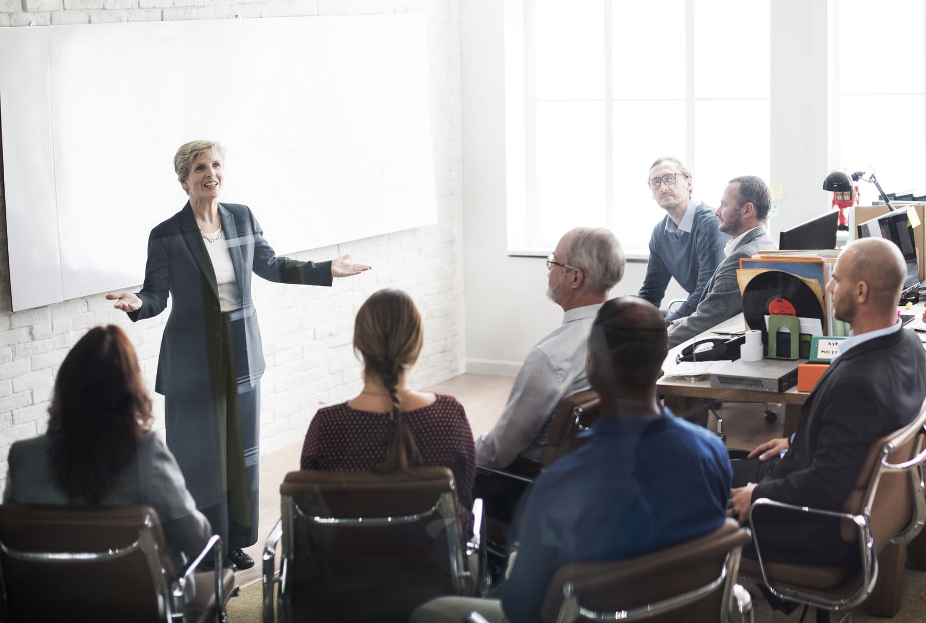 senior woman leading a meeting of several adults