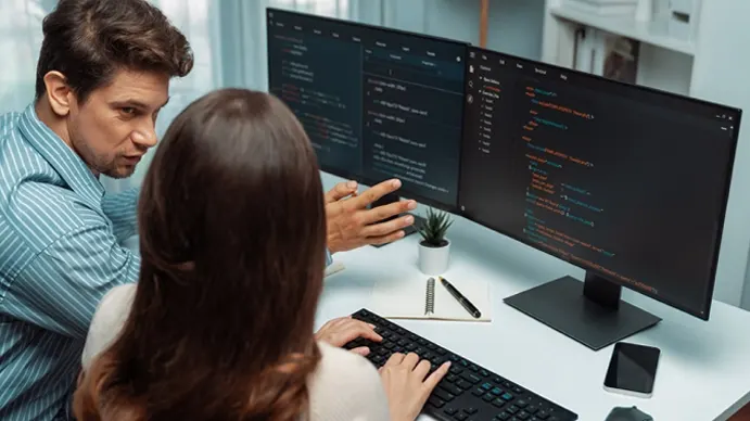Software experts working on a computer with code.