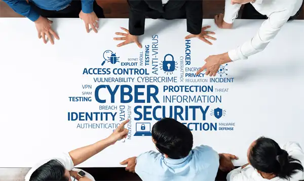 Professionals collaborating around a table analyzing cyber security concepts focused on threats, protection strategies, and data integrity in a modern office environment.